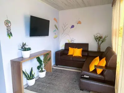 a living room with a couch and a tv at 2nd floor A/C, Wifi, Fully equipped apartment in Fortuna