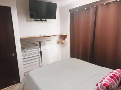 a bedroom with a bed and a flat screen tv at 2nd floor A/C, Wifi, Fully equipped apartment in Fortuna