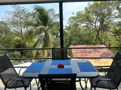 a blue table and chairs on a balcony with a palm tree at Sunset Villa - Upper Poolside in Sámara