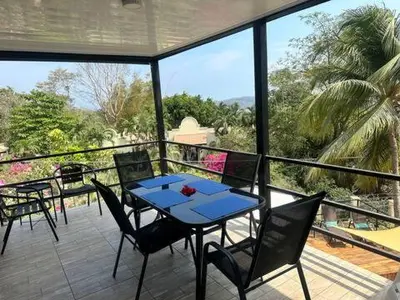a patio with a blue table and chairs on a balcony at Sunset Villa - Upper Poolside in Sámara