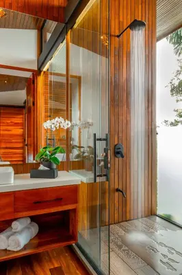 a bathroom with a shower with a glass door at Villa Morpho - Luxury Jungle House at Ecolirios Green Community in Guácimo