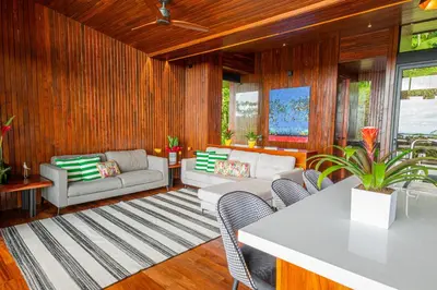 a living room with a couch and a table and chairs at Villa Morpho - Luxury Jungle House at Ecolirios Green Community in Guácimo