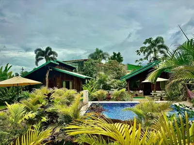 a resort with a swimming pool in front of a house at Cabañas Litos #3 in Fortuna