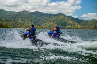 two men riding on the back of elephants in the water at Cabañas Litos #3 in Fortuna