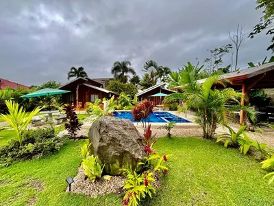 a resort yard with a rock and a swimming pool at Cabañas Litos #3 in Fortuna