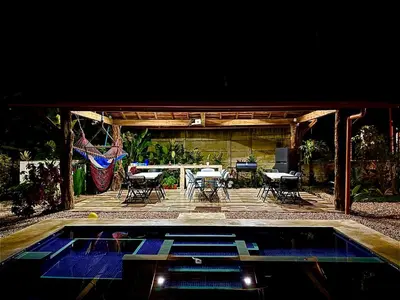 a patio with a table and chairs and a pool at Cabañas Litos #3 in Fortuna