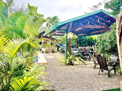 a patio with tables and chairs and a blue canopy at Cabañas Litos #3 in Fortuna