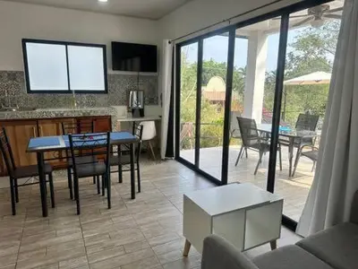 a kitchen and living room with a table and chairs at Sunset Villa - Stunning Poolside in Sámara
