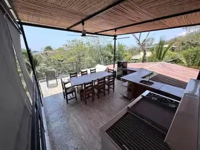 a patio with a table and chairs on a deck at Sunset Villa - Stunning Poolside in Sámara