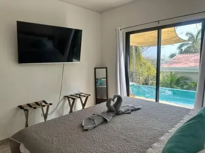a room with a towel on a bed with a television at Sunset Villa - Stunning Poolside in Sámara