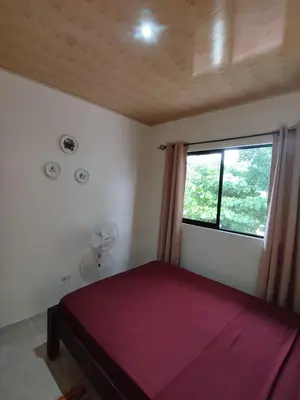 a bedroom with a red bed and a window at Apartamento la paz N°2 in Liberia