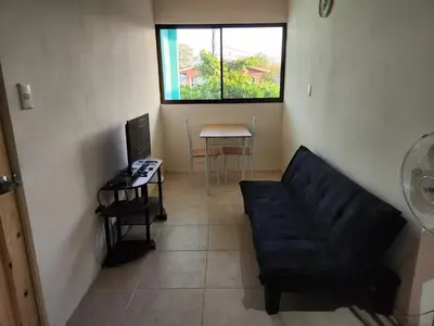 a living room with a black couch and a table at Apartamento la paz N°2 in Liberia
