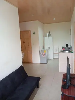 a living room with a black couch and a kitchen at Apartamento la paz N°2 in Liberia