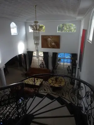 a spiral staircase with a chandelier in a house at Alameda Cariari Boutique Hotel in San José