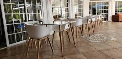 a row of tables and chairs in a room with windows at Alameda Cariari Boutique Hotel in San José
