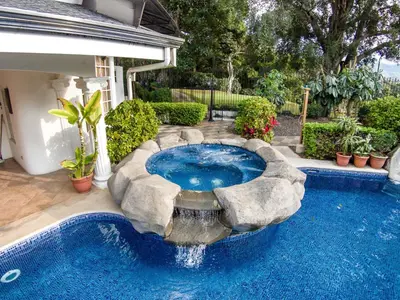 a swimming pool with a fountain in a yard at Alameda Cariari Boutique Hotel in San José