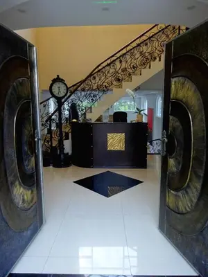 a room with a staircase with a clock in a mirror at Alameda Cariari Boutique Hotel in San José