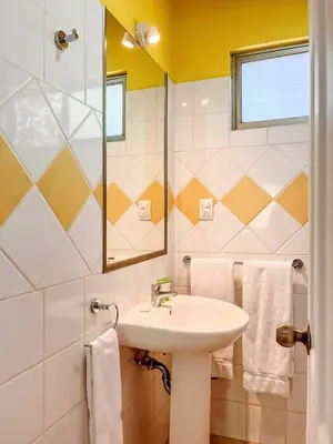 a bathroom with a sink and a mirror and towels at Sueño al Mar Residence & Hotel in Potrero