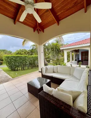 a patio with white couches and a ceiling fan at Sueño al Mar Residence & Hotel in Potrero