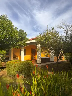 a yellow house with flowers in front of it at Sueño al Mar Residence & Hotel in Potrero