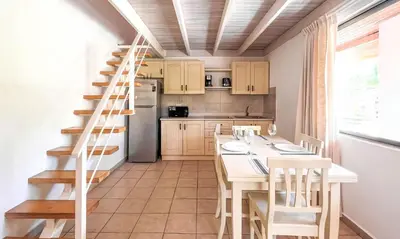 a kitchen with a staircase and a table and chairs at Sueño al Mar Residence & Hotel in Potrero
