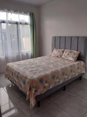 a bed in a bedroom with a blanket on it at Arenal Vistas del Paraiso in Nuevo Arenal