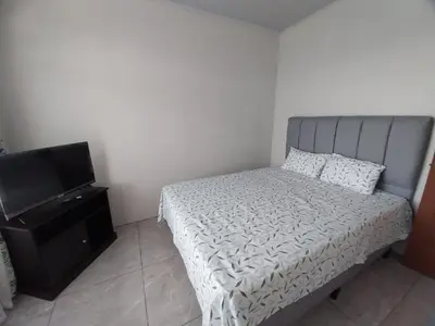 a bedroom with a bed and a flat screen tv at Arenal Vistas del Paraiso in Nuevo Arenal