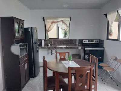 a kitchen with a table and a black refrigerator at Arenal Vistas del Paraiso in Nuevo Arenal