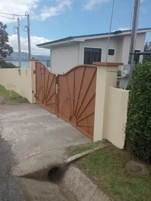 a wooden gate in front of a house at Arenal Vistas del Paraiso in Nuevo Arenal