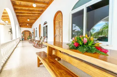 a porch with a wooden bench with flowers on it at Hotel Mar Rey in Tamarindo