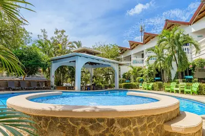 a pool with a gazebo in front of a house at Hotel Mar Rey in Tamarindo