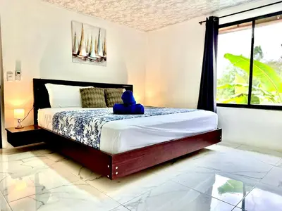 a bedroom with a bed with a stuffed animal sitting on it at Blu House Nature & Tours in Chachagua