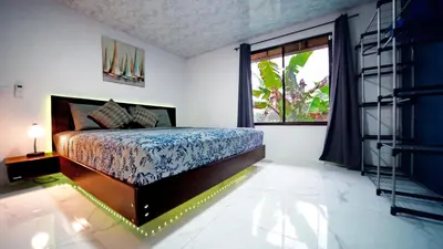 a bedroom with a bed and a large window at Blu House Nature & Tours in Chachagua