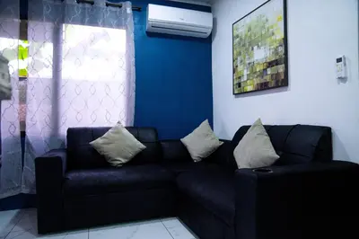 a living room with a black couch and a blue wall at Blu House Nature & Tours in Chachagua