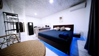 a bedroom with a bed with blue sheets and a chair at Blu House Nature & Tours in Chachagua