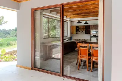 a kitchen with glass doors and a table and chairs at Cloud Forest House Monteverdes in Monteverde Costa Rica