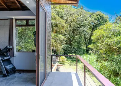 an open door to a balcony with a view of trees at Cloud Forest House Monteverdes in Monteverde Costa Rica