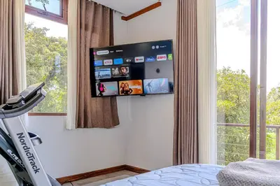 a bedroom with a flat screen tv on the wall at Cloud Forest House Monteverdes in Monteverde Costa Rica