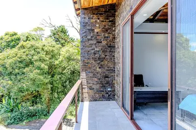 a balcony of a house with a brick wall at Cloud Forest House Monteverdes in Monteverde Costa Rica