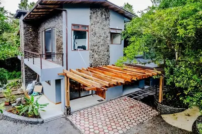 a house with a wooden deck and a balcony at Cloud Forest House Monteverdes in Monteverde Costa Rica