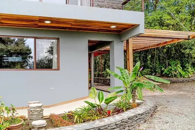 a white house with a wooden roof at Cloud Forest House Monteverdes in Monteverde Costa Rica