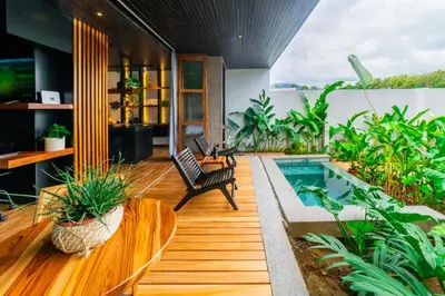 an indoor garden with a pool and chairs and plants at Danta Santa Lofts in Fortuna