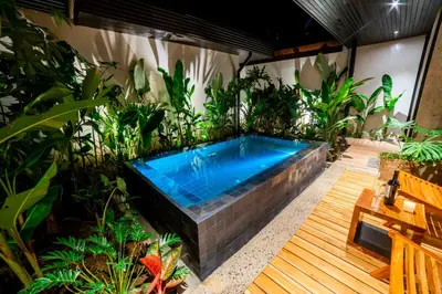 a hot tub in a garden with plants at Danta Santa Lofts in Fortuna