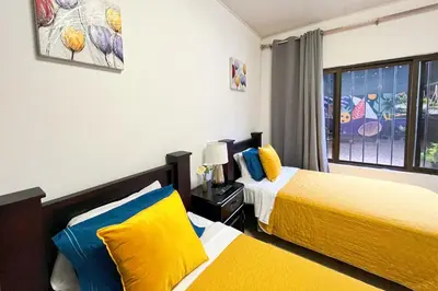 a bedroom with two beds and a window at Viva Guest House in San José