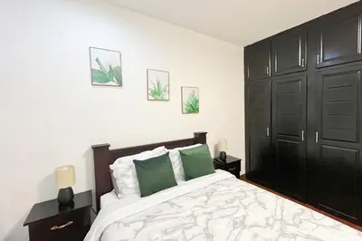 a bedroom with a large bed with green pillows at Viva Guest House in San José