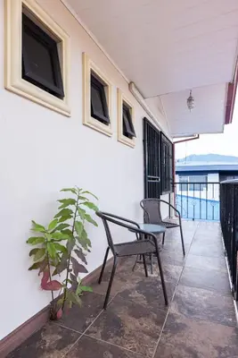 a patio with two chairs and a table and a plant at Viva Guest House in San José