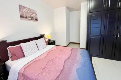 a bedroom with a large bed and a black door at Viva Guest House in San José