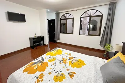 a bedroom with a bed with a yellow and white blanket at Viva Guest House in San José