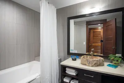 a bathroom with a tub and a sink and a mirror at Crocs Resort & Casino in Jacó