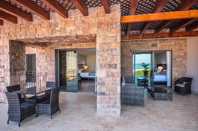 an outdoor patio with a brick wall and a table and chairs at Crocs Resort & Casino in Jacó